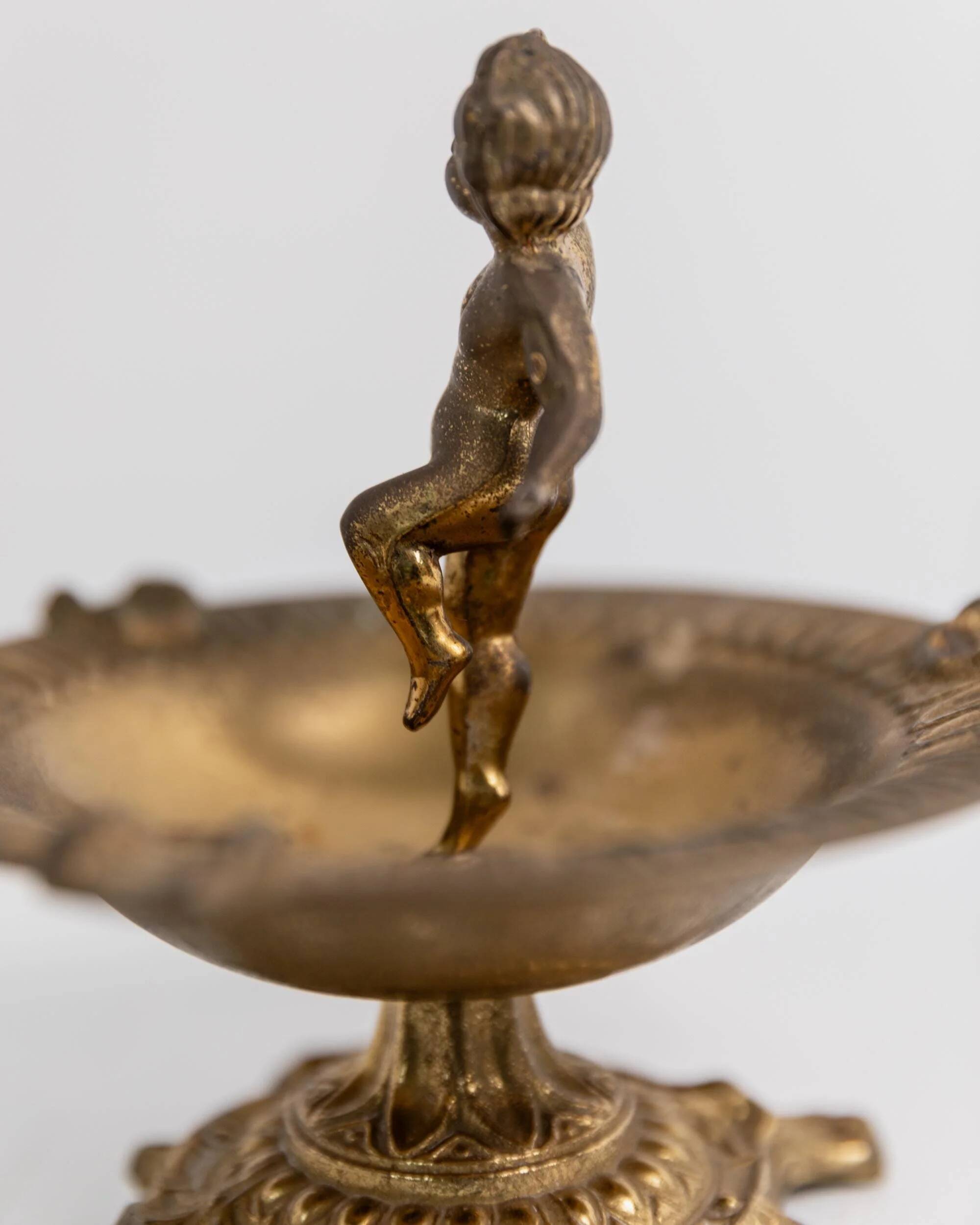 Vintage brass ashtray from the 1940s with a nude boy figurine on a footed base.