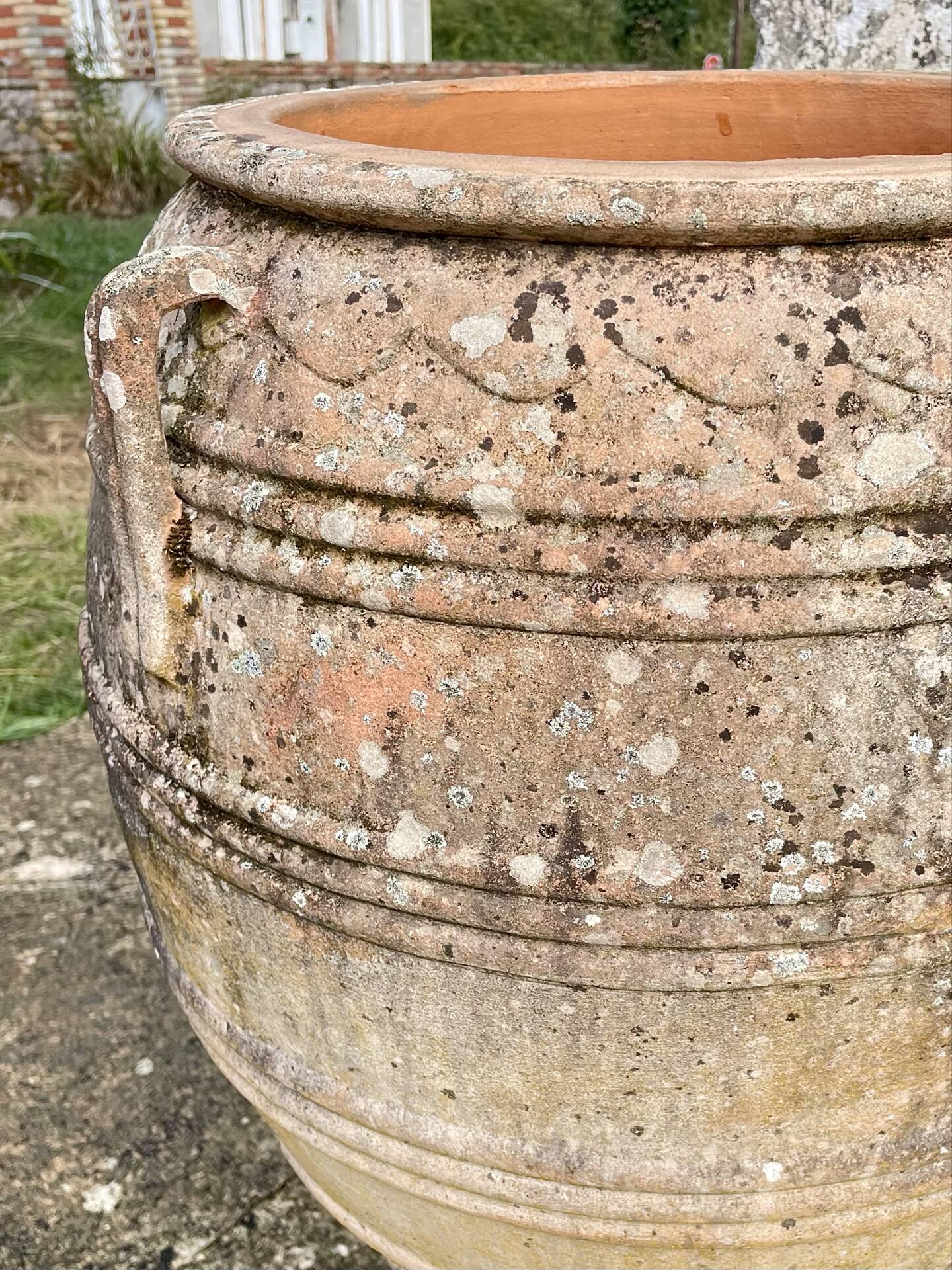 Large Cretan jar in terracotta with three handles on a stone base.