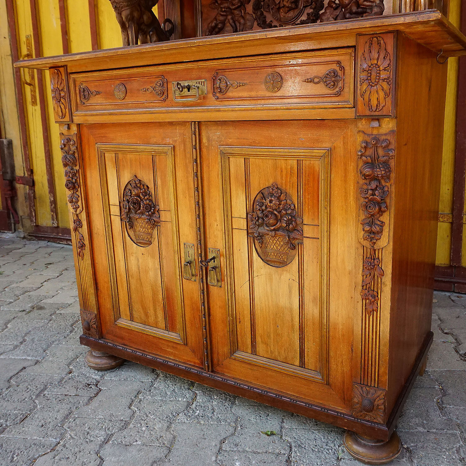 Antique carved wooden sideboard with several sculptures.