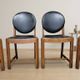 Set of four vintage wooden dining chairs with black leather upholstery