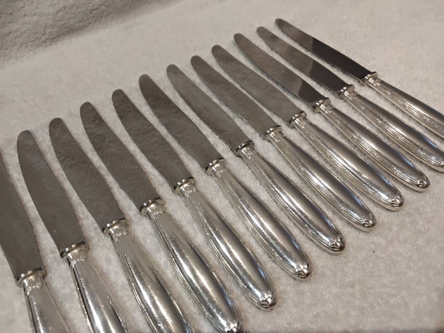 12 silver-plated table knives, Christofle goldsmith ribbons