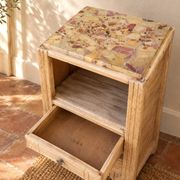 Small Art Deco bedside table in light wood with a terrazzo effect top.