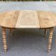 Table à manger ronde extensible à volets décapée en noyer brut 2 rallonges