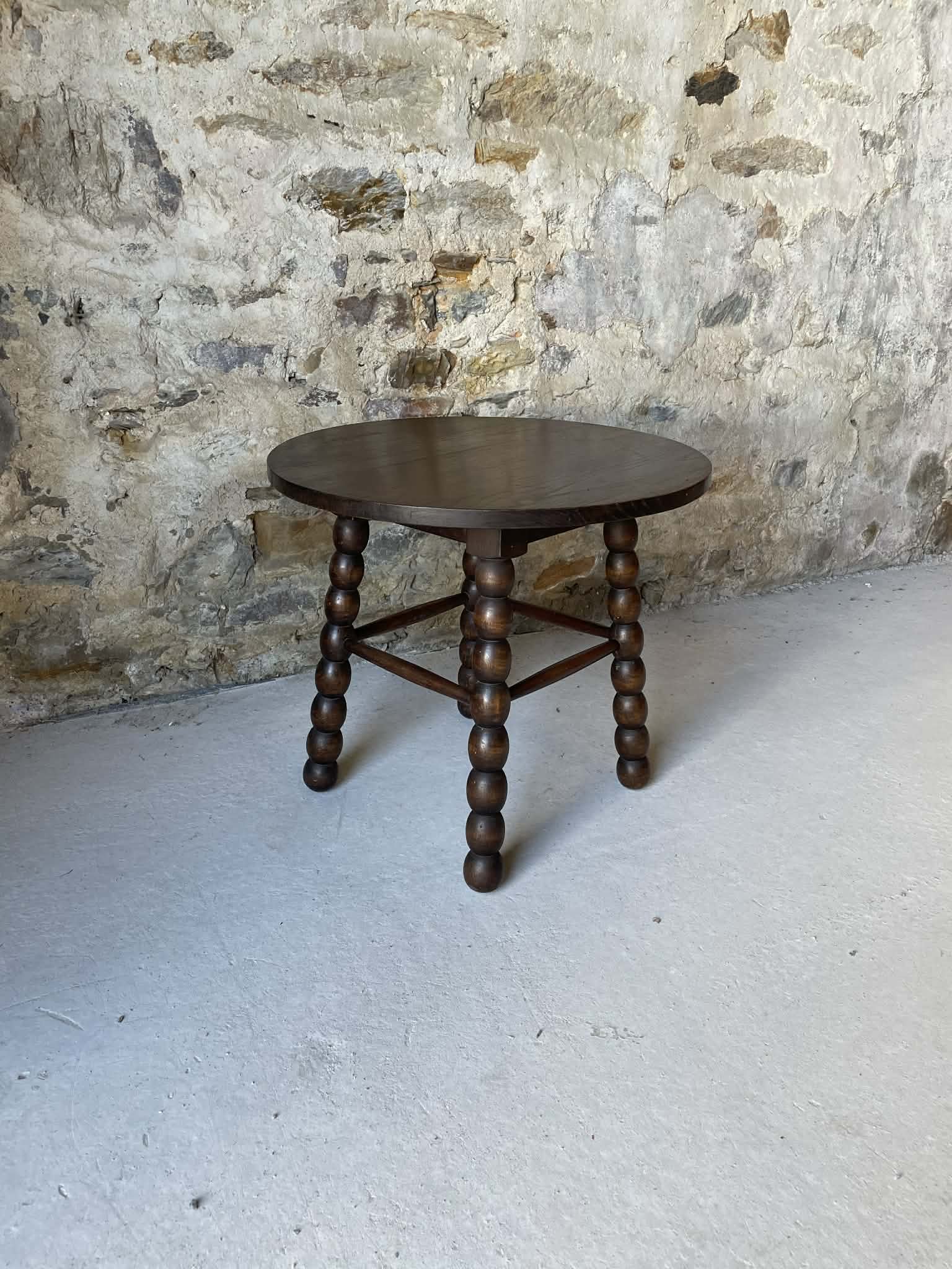 Round wooden coffee table with turned legs.