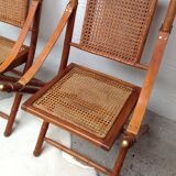 Pair of folding chairs in bamboo and caning, leather and brass