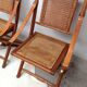 Pair of folding chairs in bamboo and caning, leather and brass