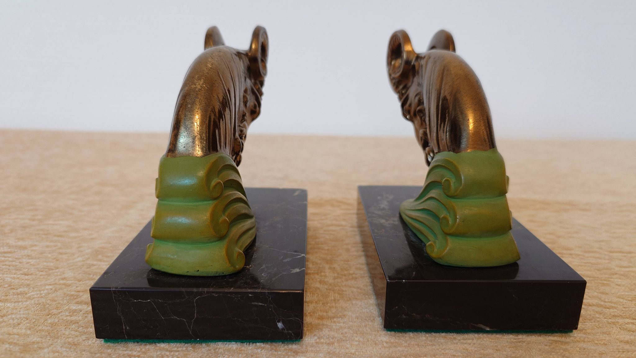 Art Deco pair of bookends with ram's heads, patinated metal and black marble.