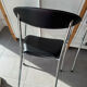 Set of two metal chairs with a brushed finish and black leather.