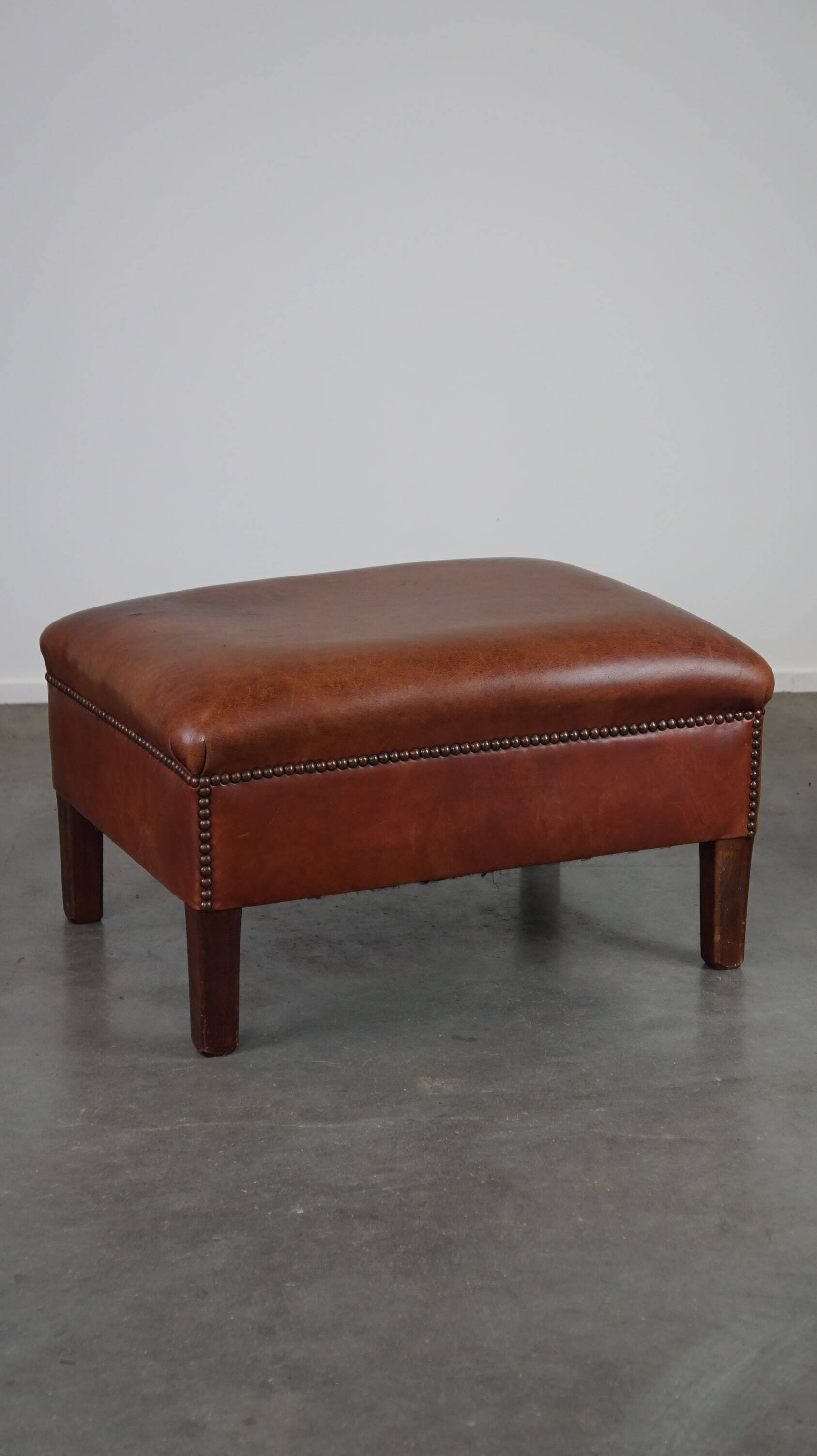 Leather ottoman in classic English style finished with decorative nails
