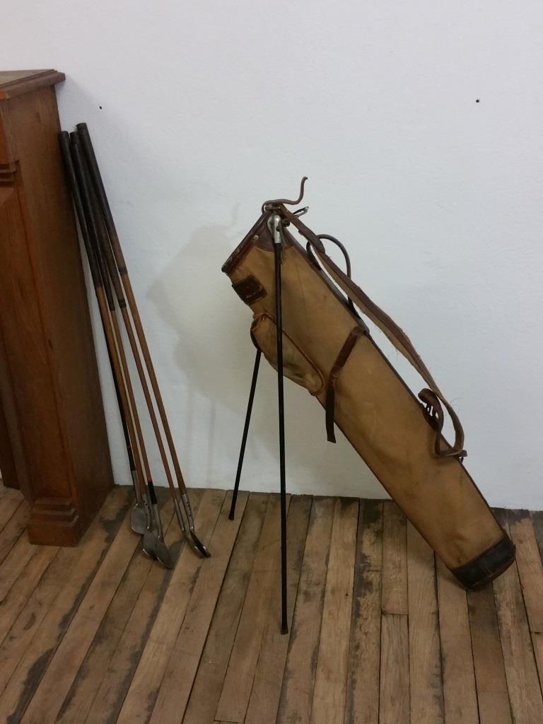 Old golf bag with 5 golf clubs