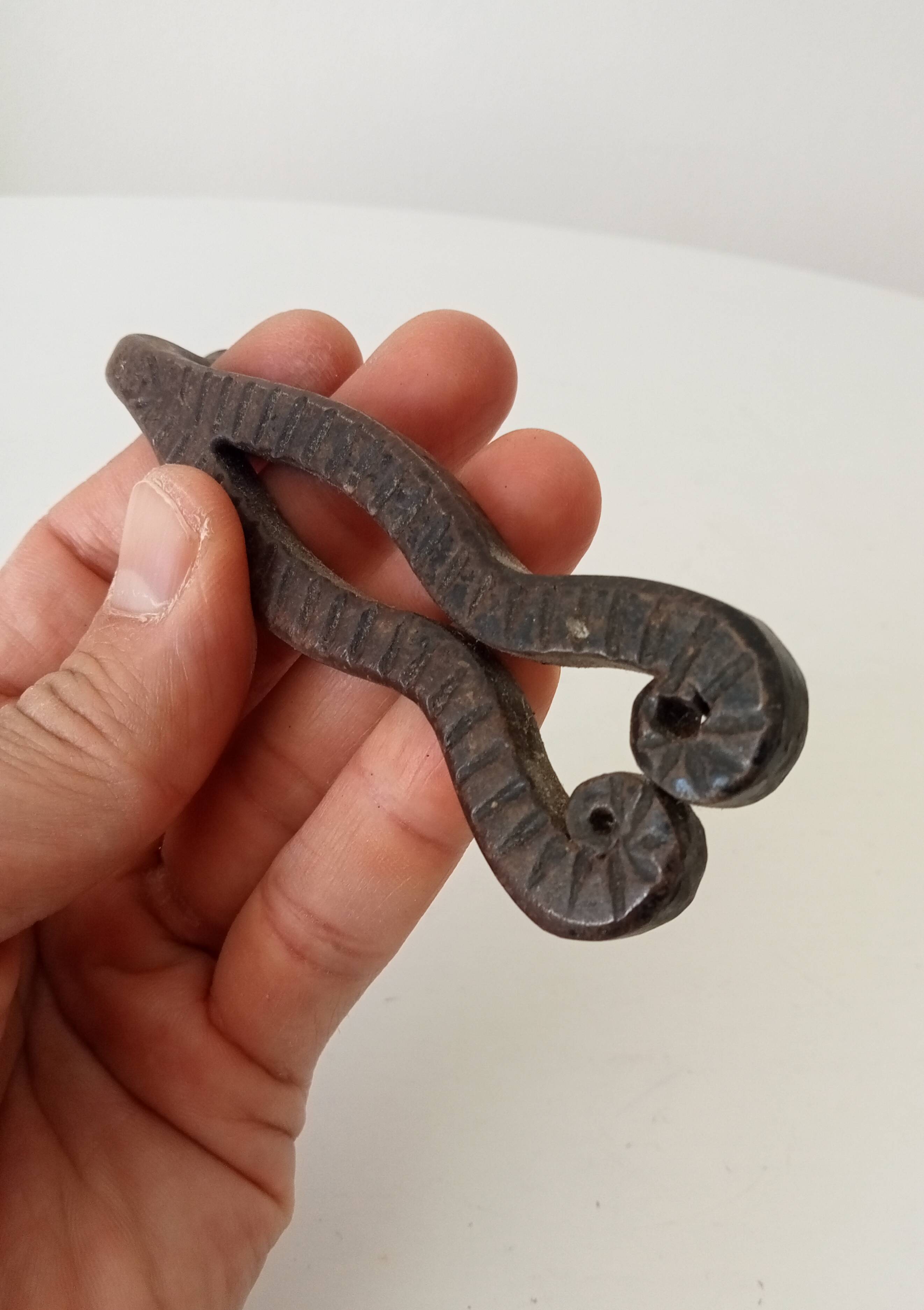 Antique wrought iron door handle with chiselled design.