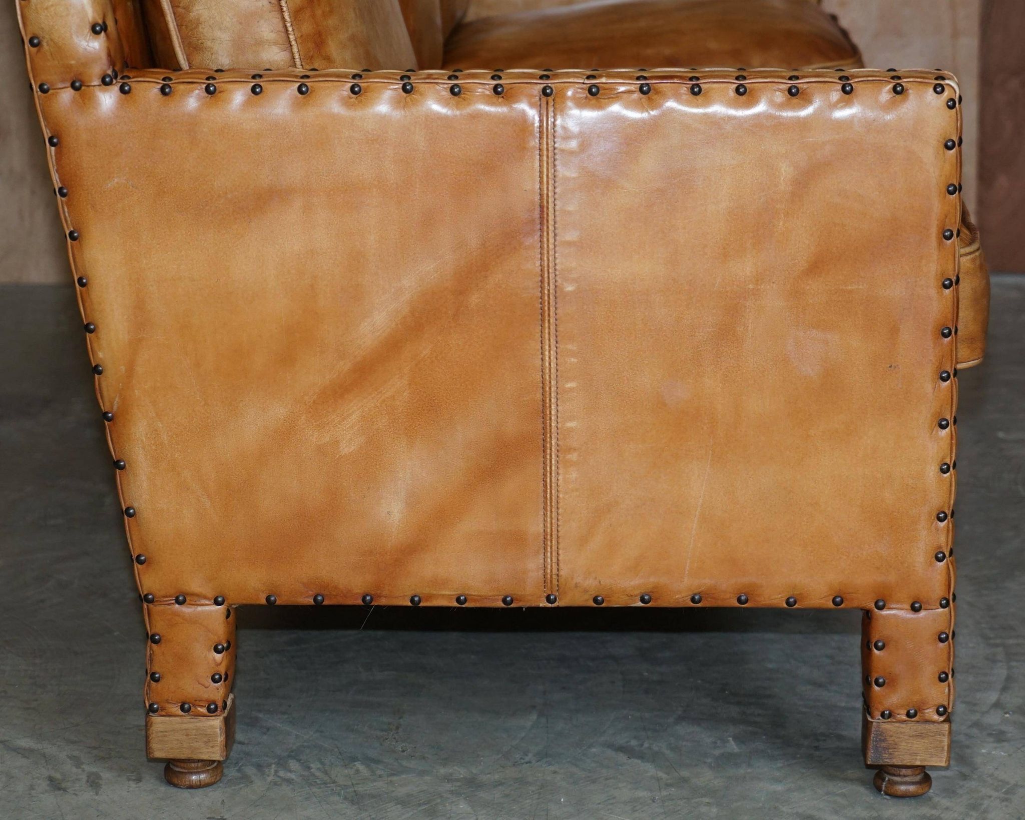 Three-seater leather canapé in Edwardian style with studs.