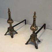 Pair of chiselled bronze and wrought iron fire dogs in the Louis XVI style.