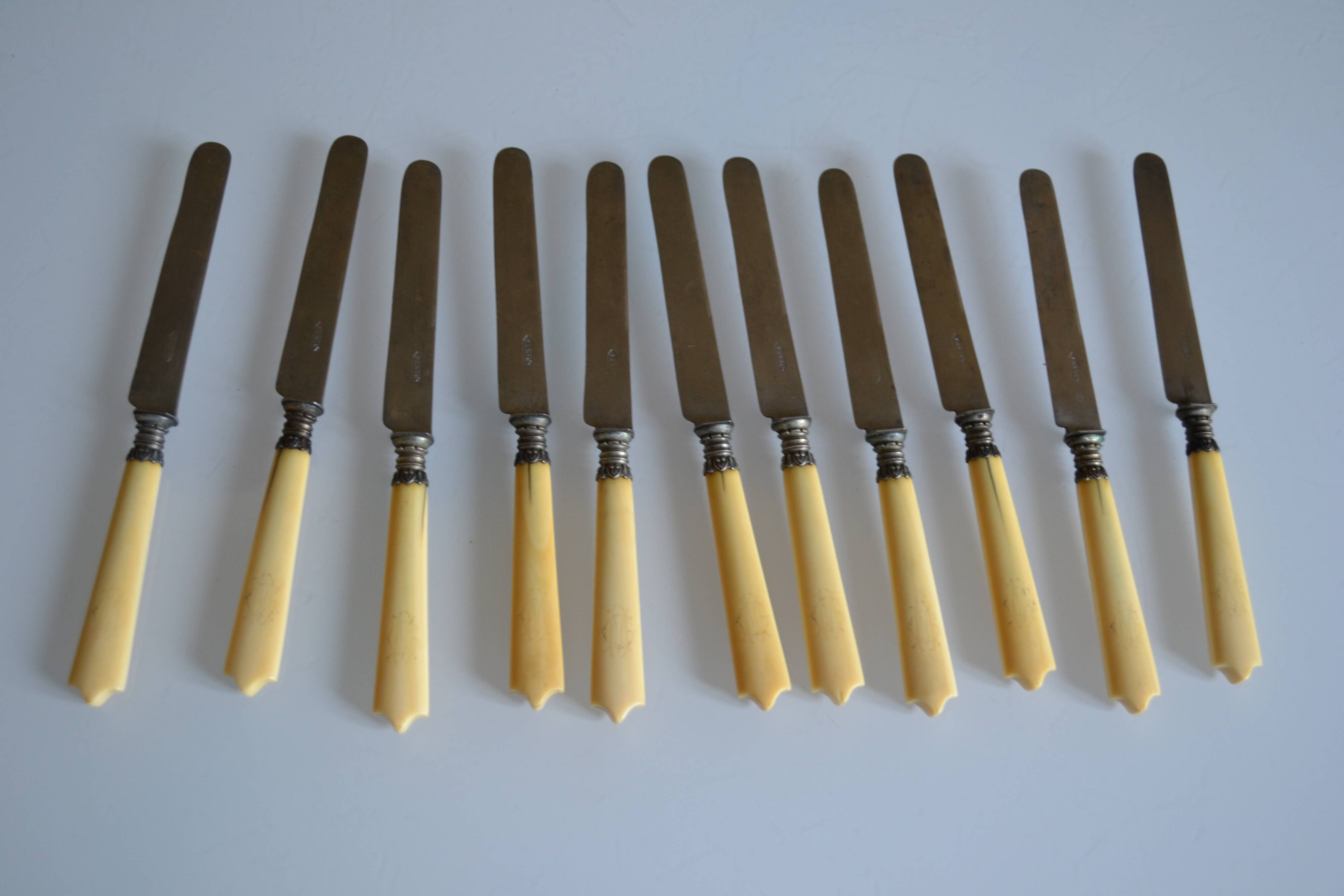 11 antique 19th-century table knives with ivory-colored monogram handles