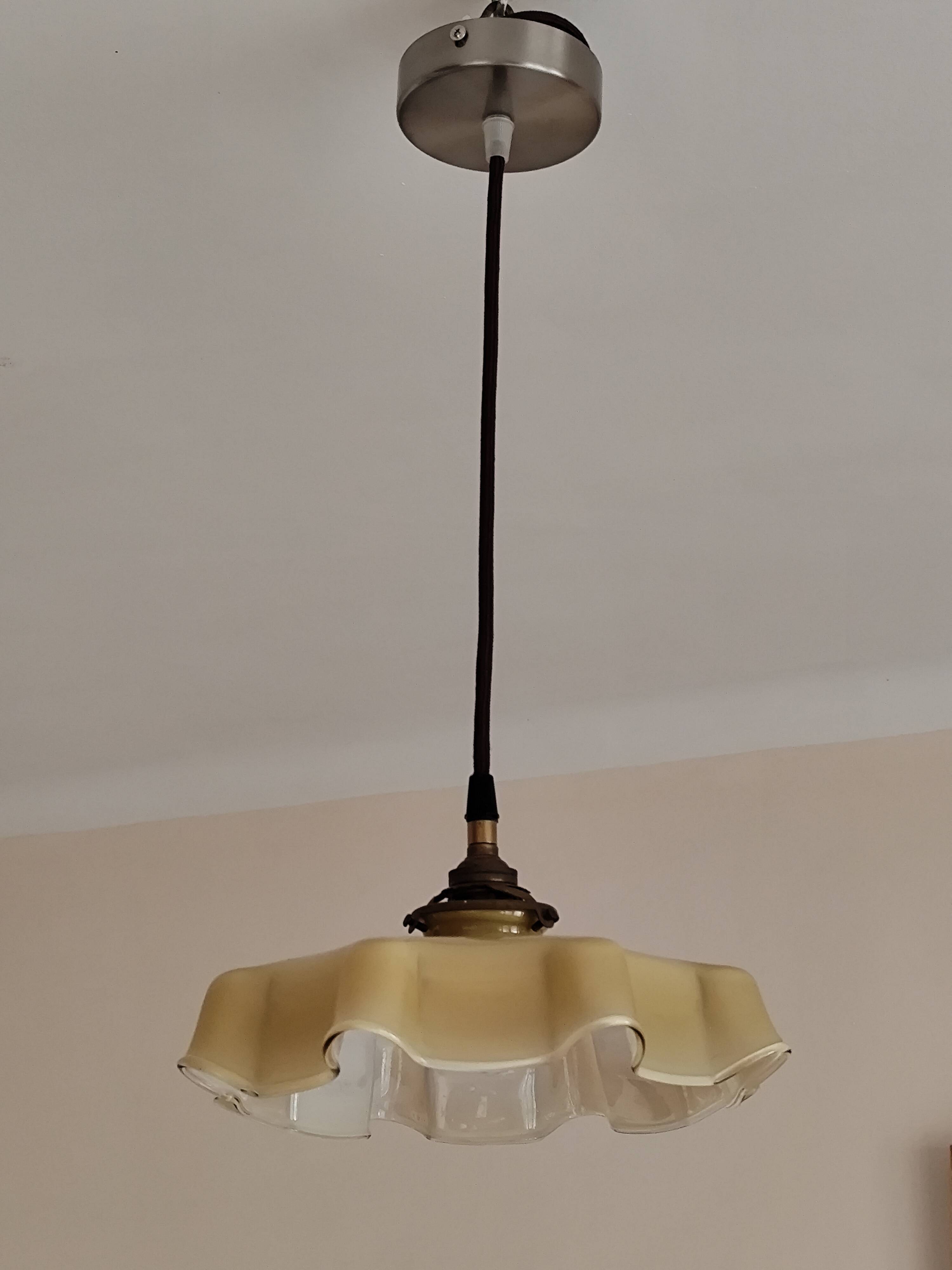 Electrified suspension with a frosted opaque glass disc shade.