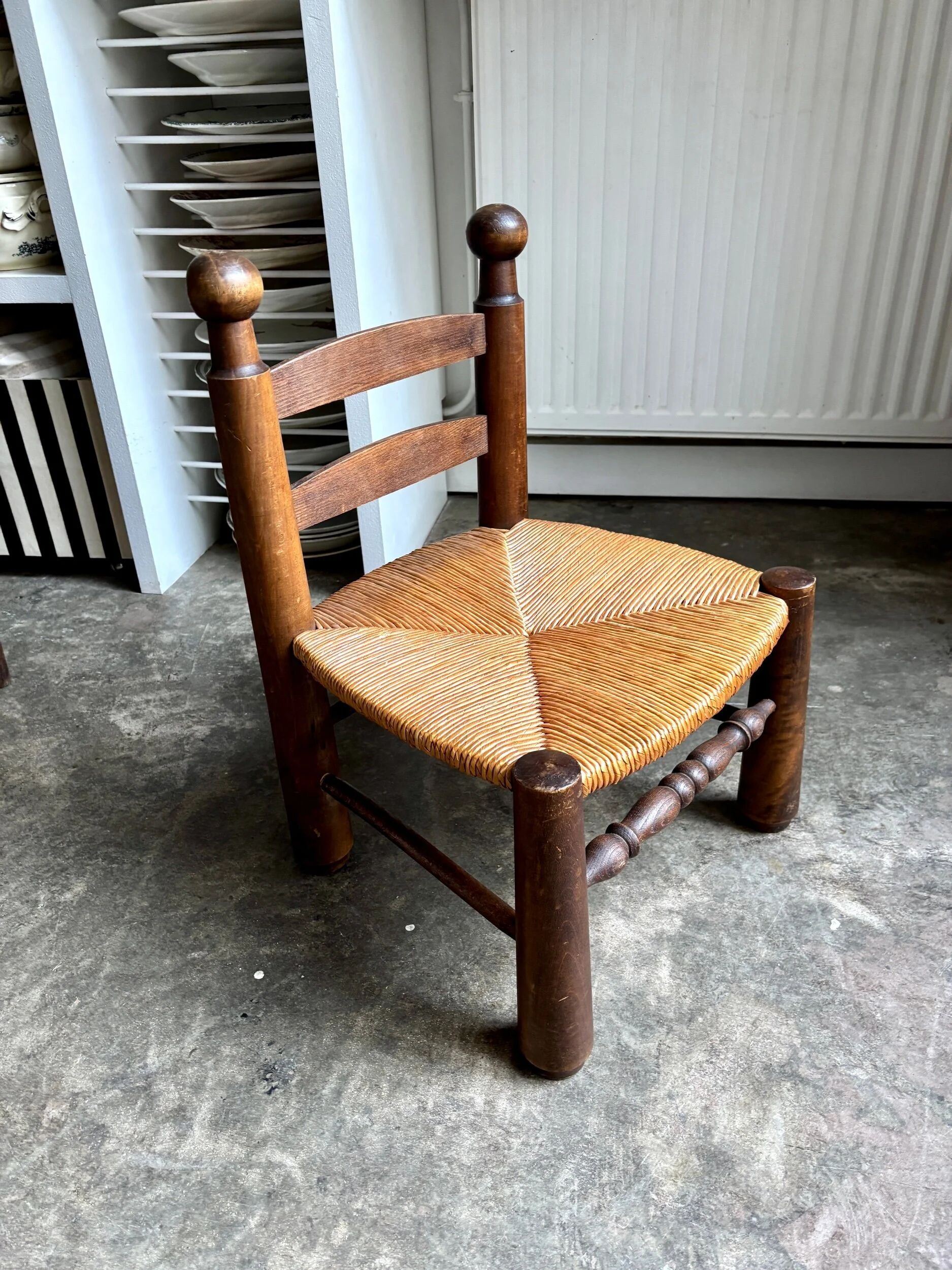Brutalist low chair in dark wood and straw no. 1
