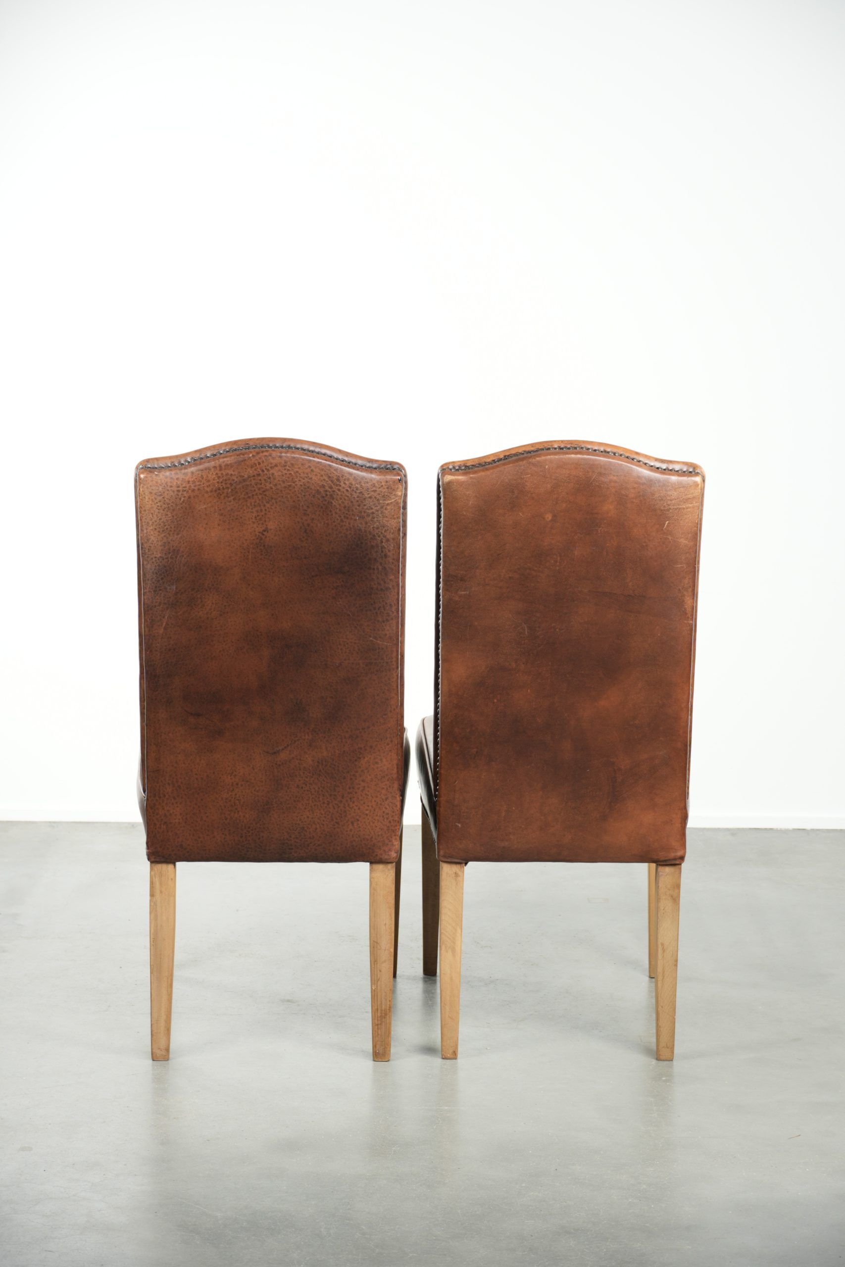 Set of 2 characterful dining chairs of sheepskin leather with a high back