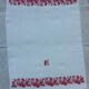 Serviette dammassée rouge et blanc avec initiale "h"