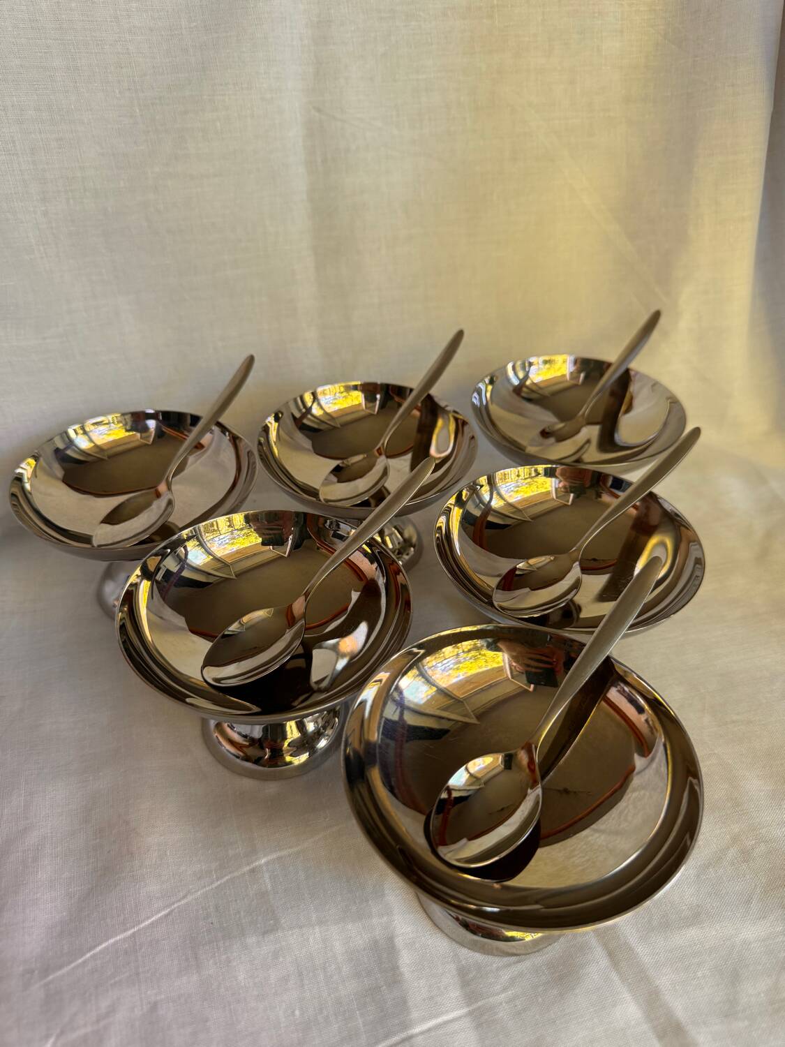 Set of 6 stainless steel ice cream bowls by Guy Degrenne with matching spoons.
