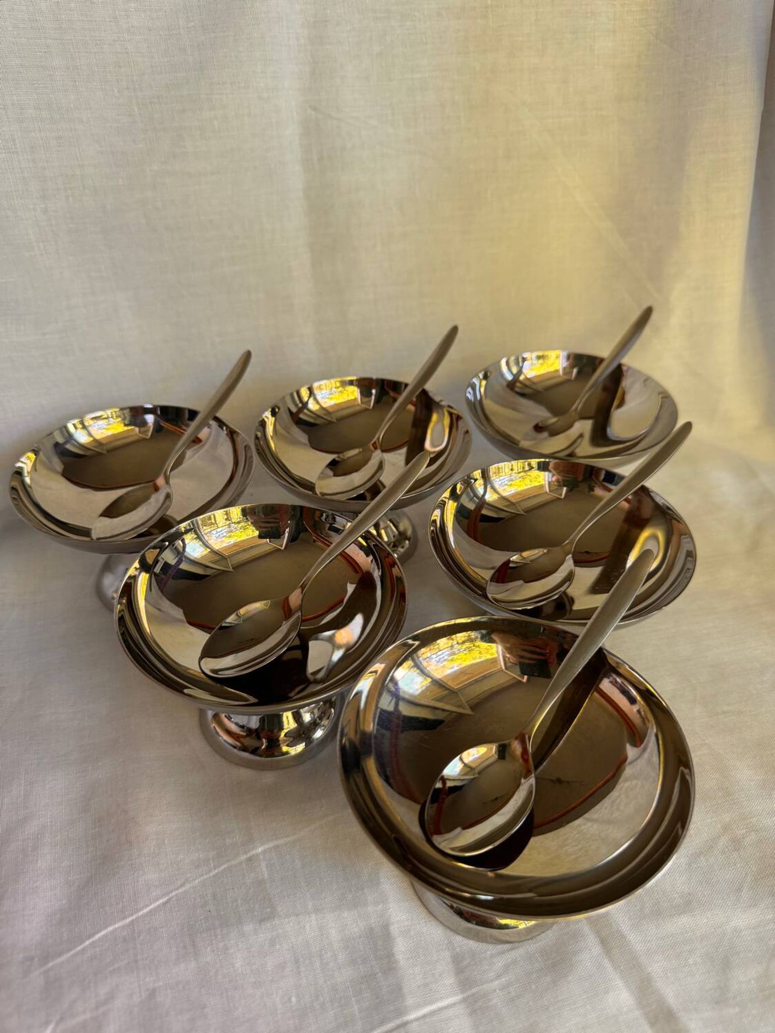 Set of 6 stainless steel ice cream bowls by Guy Degrenne with matching spoons.