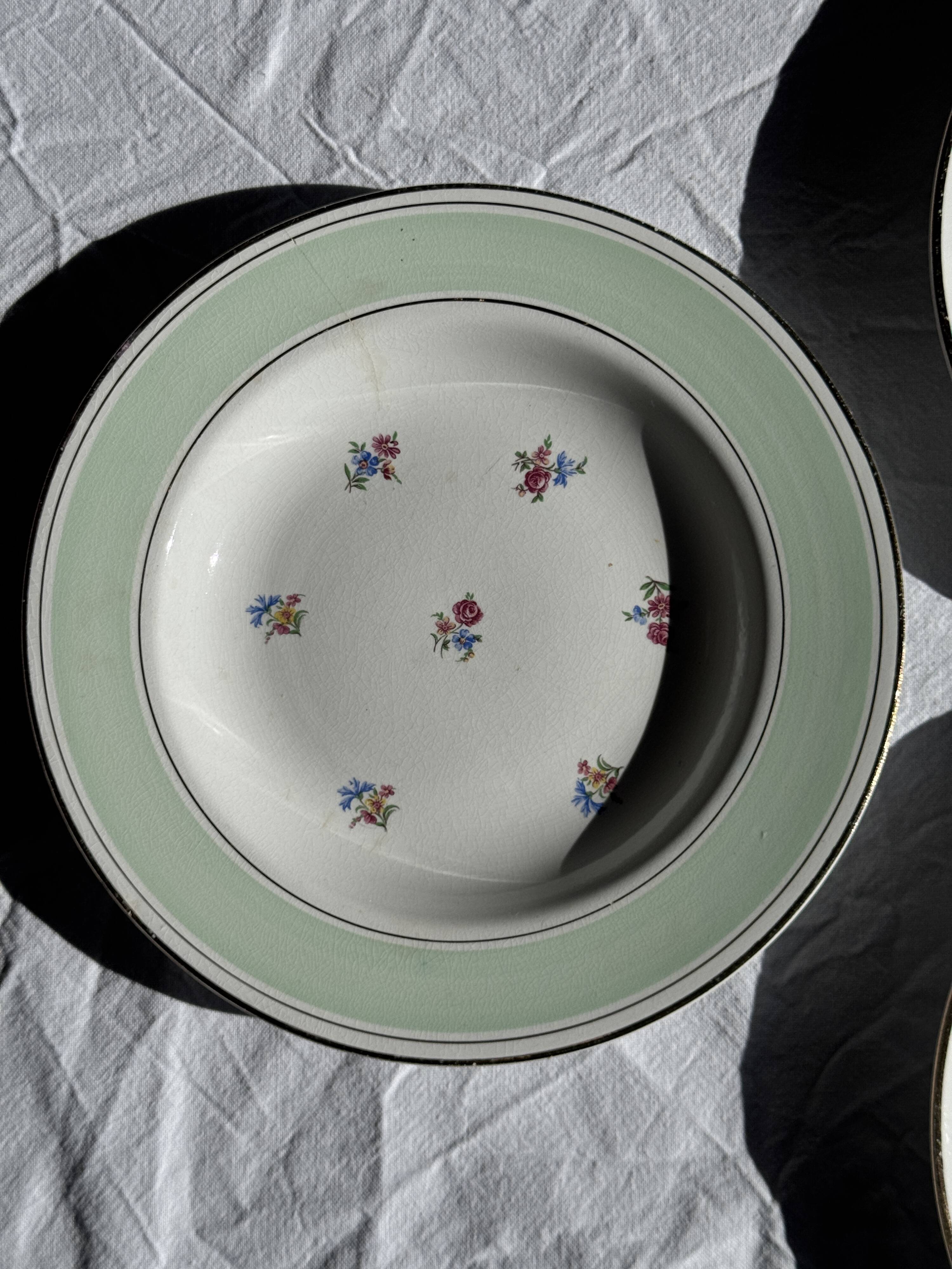 Set of 9 vintage turquoise deep plates with gold trim and pink flowers.