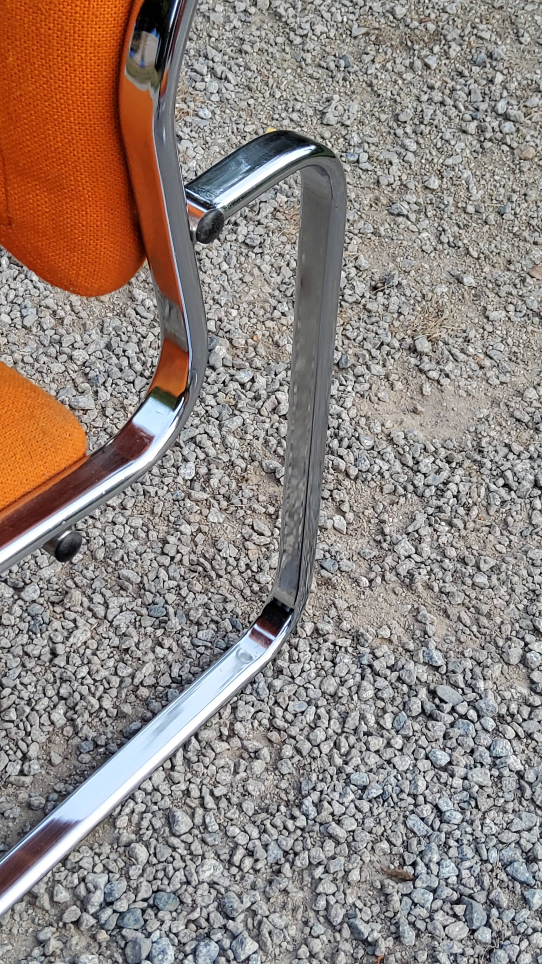 Pair of designer armchairs in orange fabrics and chrome tubes from the 70s