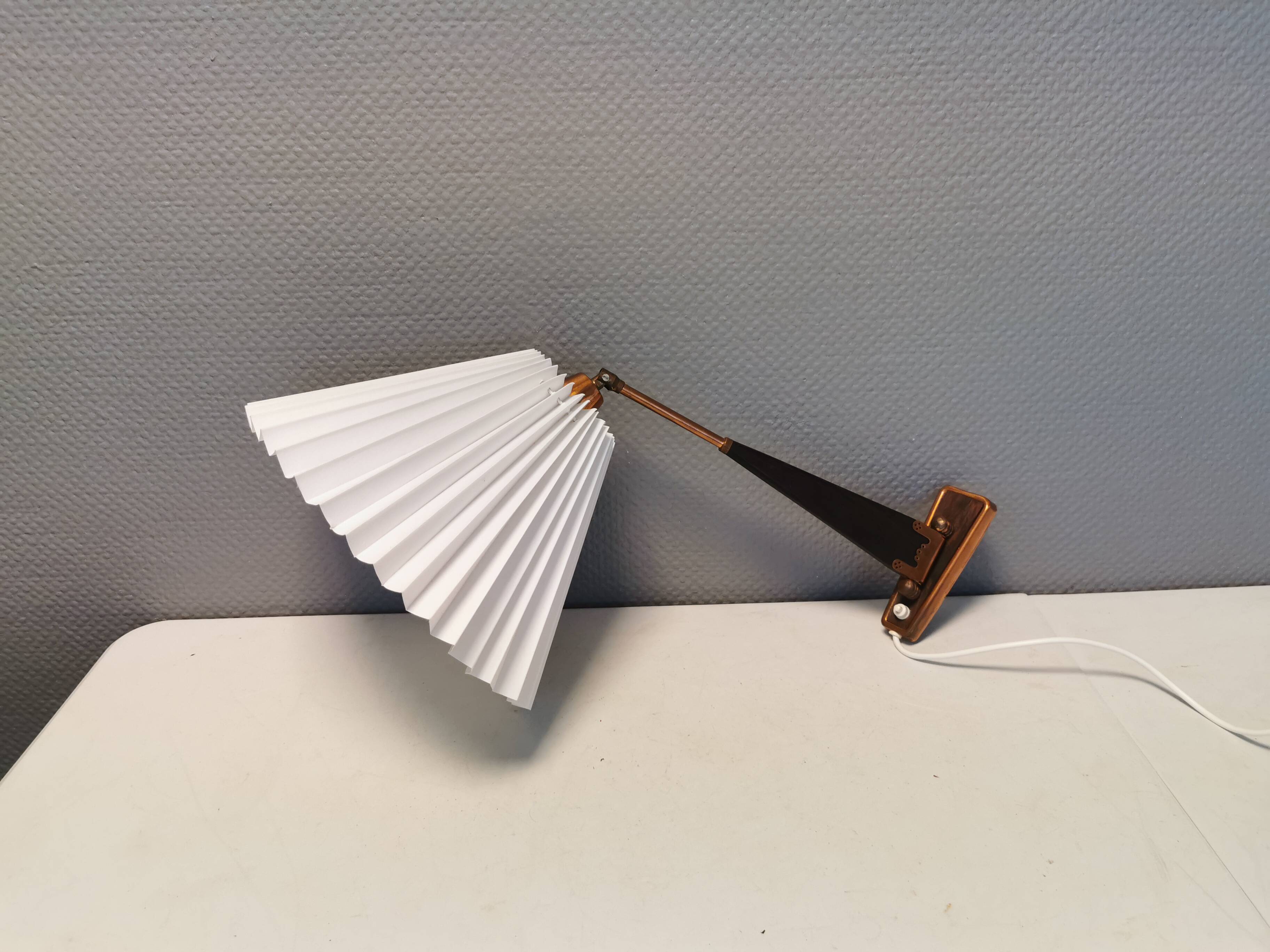 Wall lamp with adjustable ‘arm’ in copper and rosewood, with white shade.
