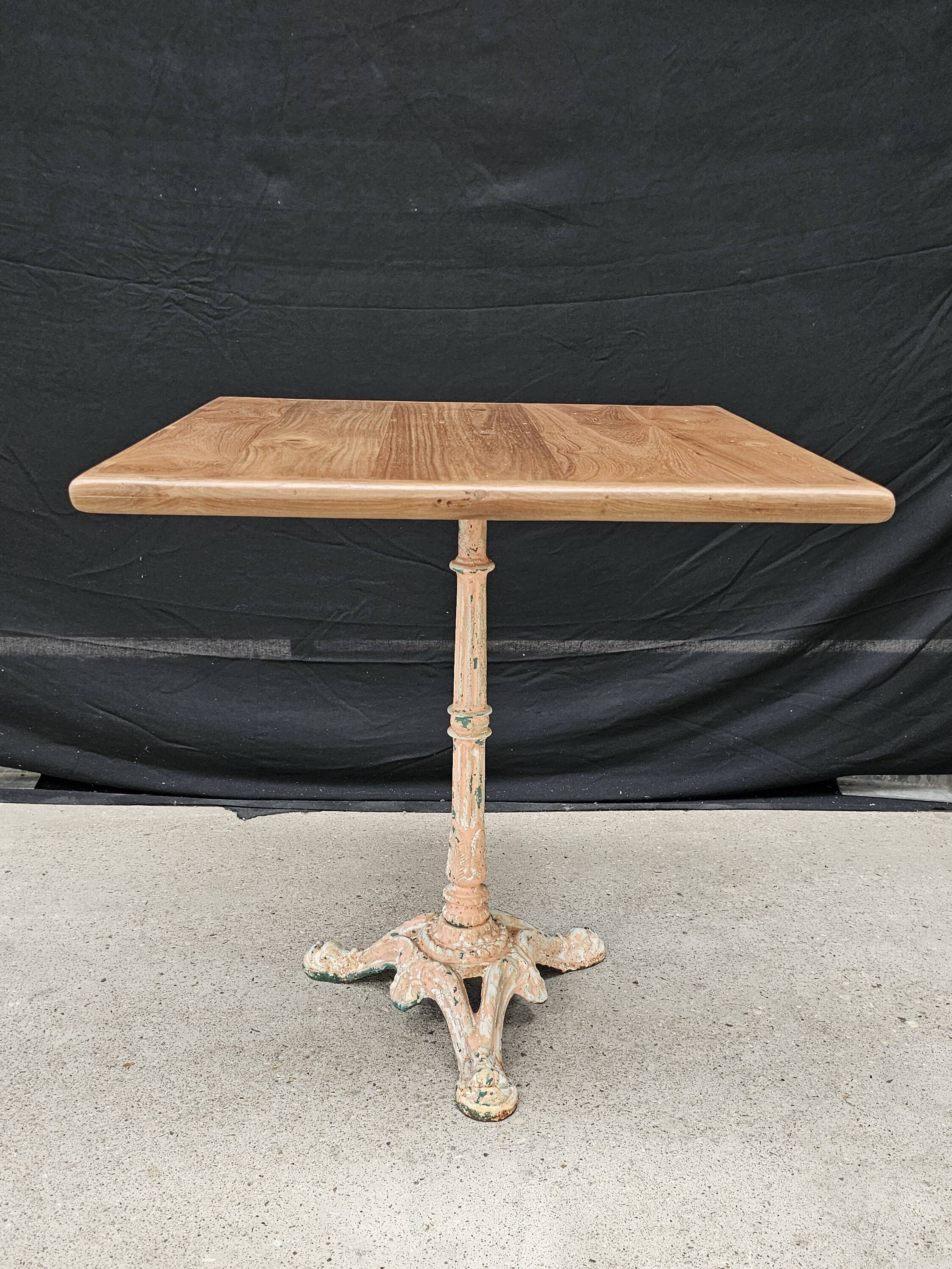 Bistro table with cast iron base and solid teak top
