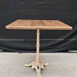 Bistro table with cast iron base and solid teak top