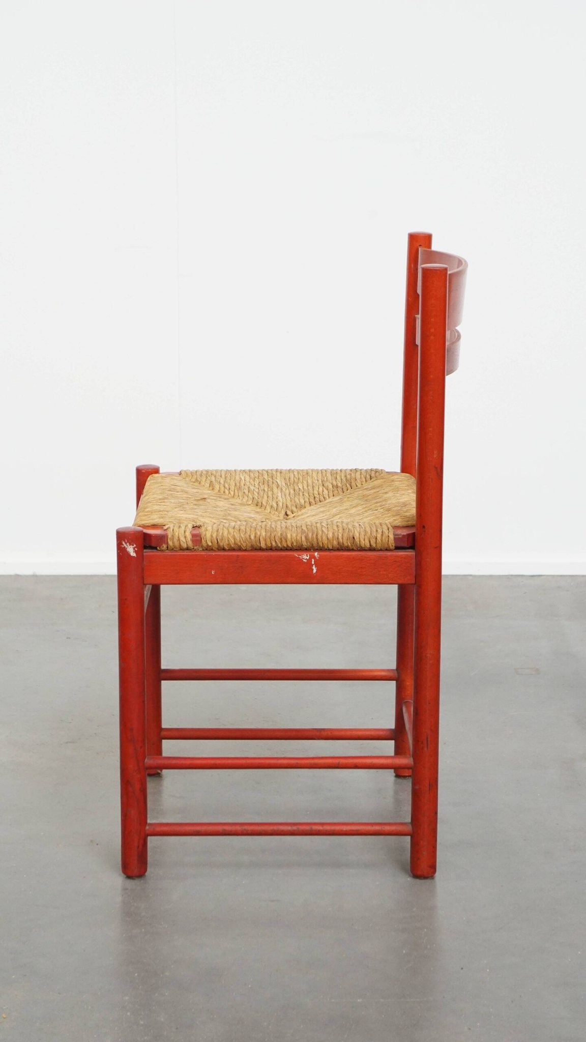 Vintage 1970s red wooden chair with a woven wicker seat