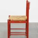 Vintage 1970s red wooden chair with a woven wicker seat