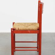 Vintage 1970s red wooden chair with a woven wicker seat