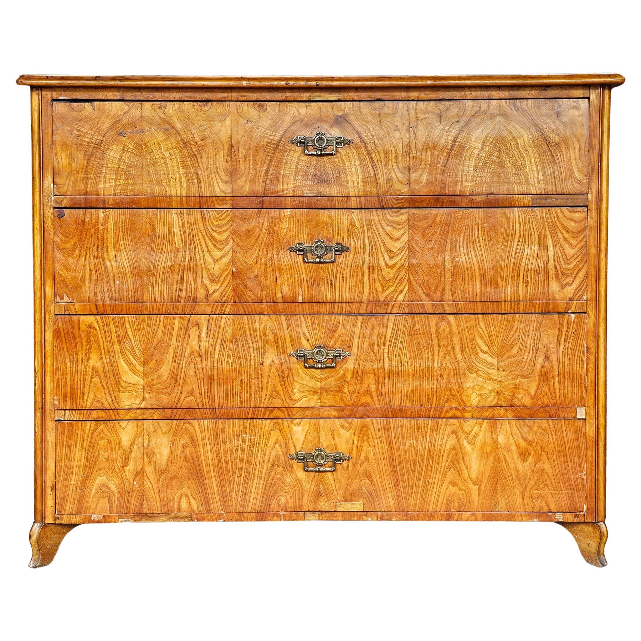 Large antique Biedermeier-style chest of drawers with wood grain.