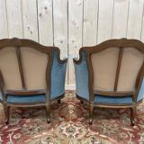 Paire de fauteuils bergères de style Louis XV en velours bleu et bois doré