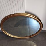Large and elegant oval gilded mirror with its beveled glass