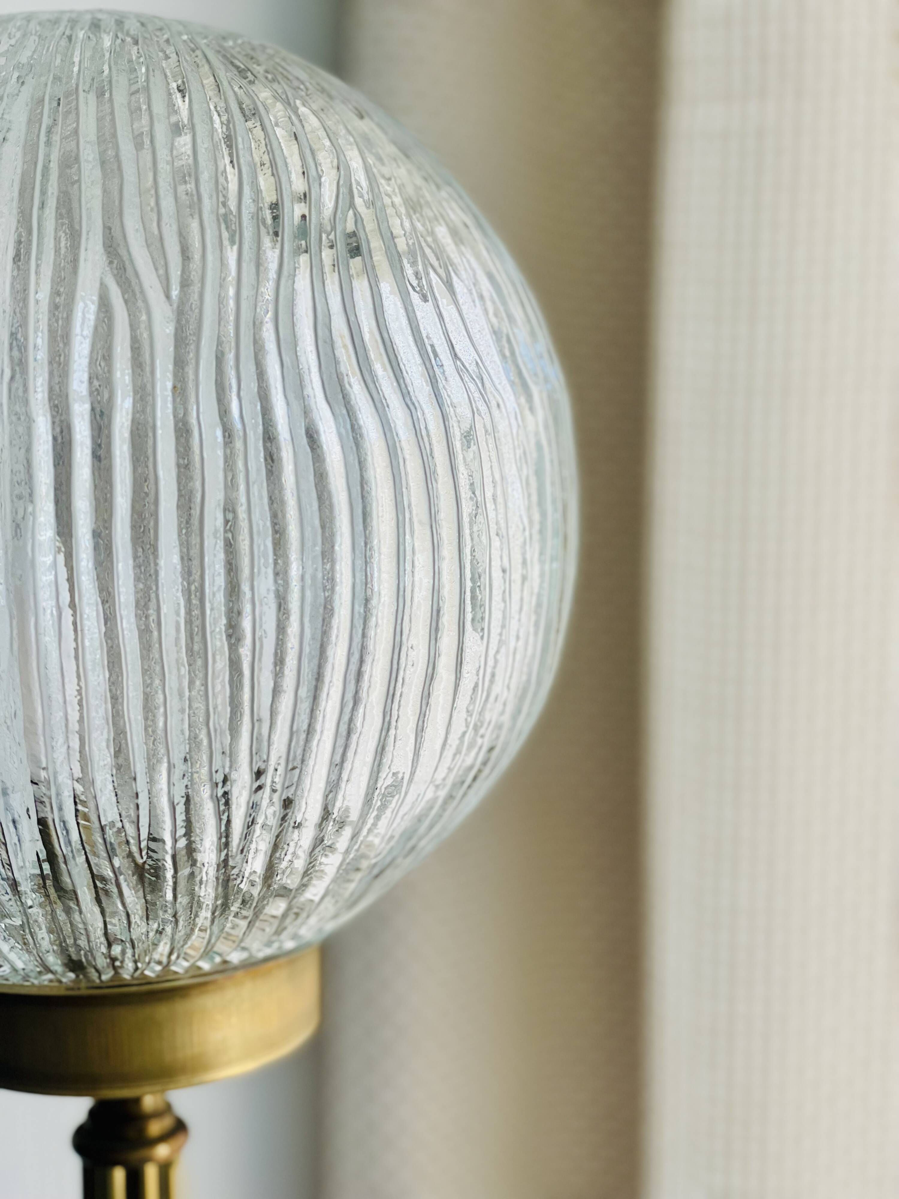 Floor lamp in gilded brass and round glass globe