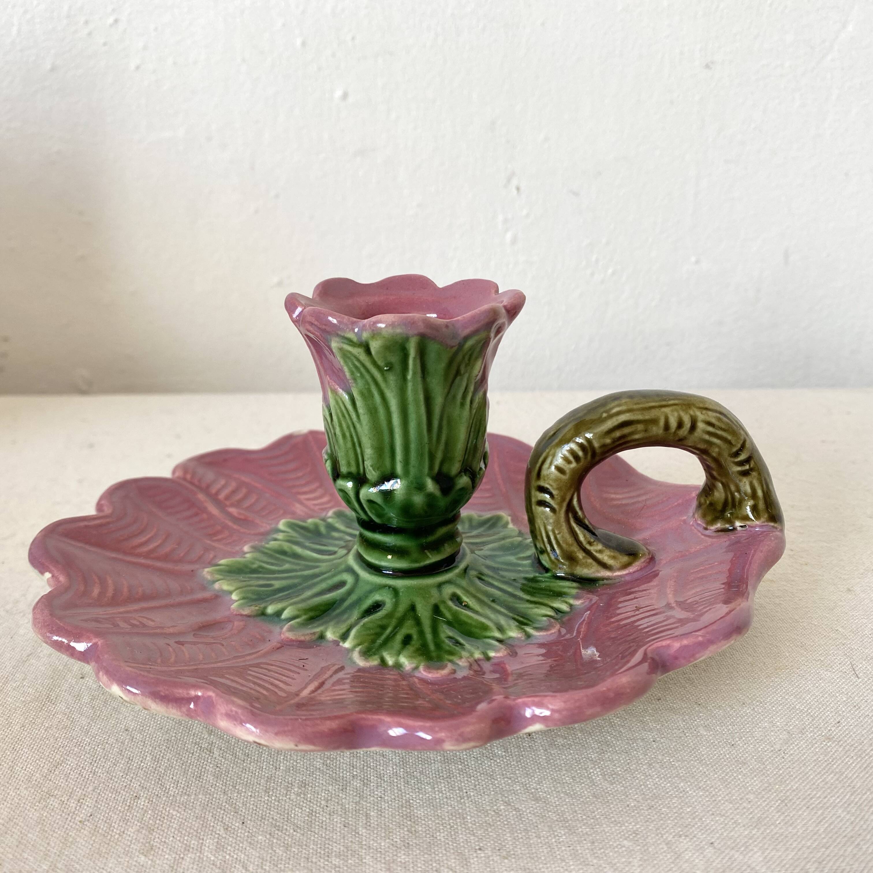 Antique slip candlestick depicting a flower