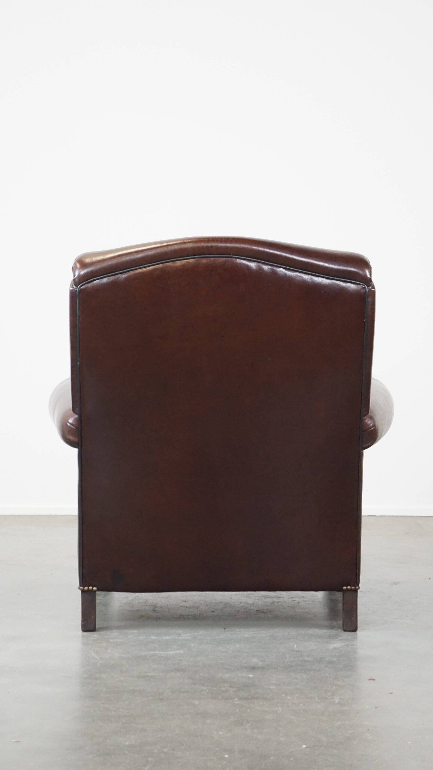 Comfortable and correct dark antique sheepskin English armchair in very good condition