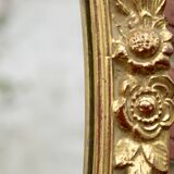 Old large oval wall mirror in golden resin