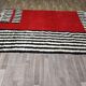 Tapis artisanal rouge et à rayures blanches et noires