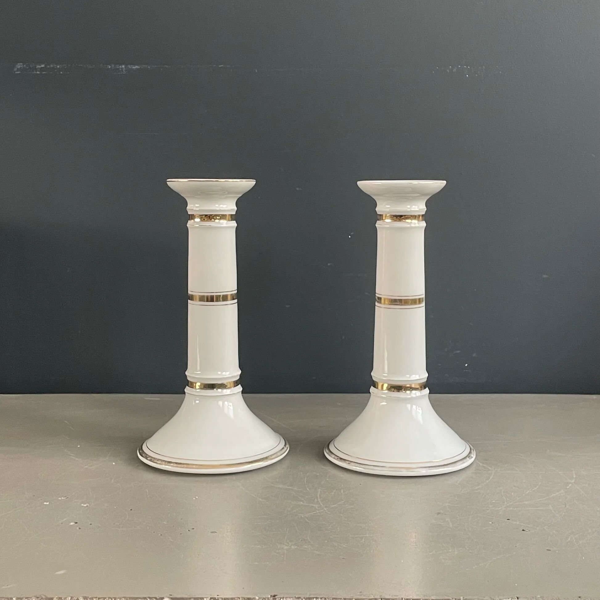 Pair of porcelain candlesticks with a gold pattern.