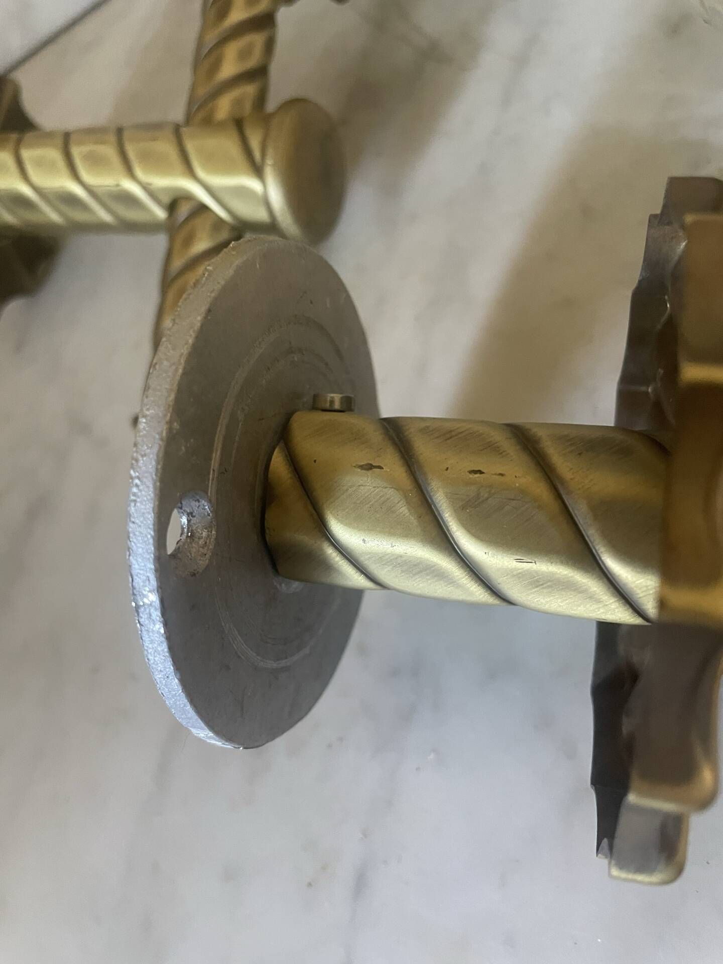 Pair of neoclassical wall sconces in twisted brass and ribbed glass.