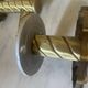 Pair of neoclassical wall sconces in twisted brass and ribbed glass.