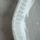 Oval white porcelain ramekin — raised floral pattern
