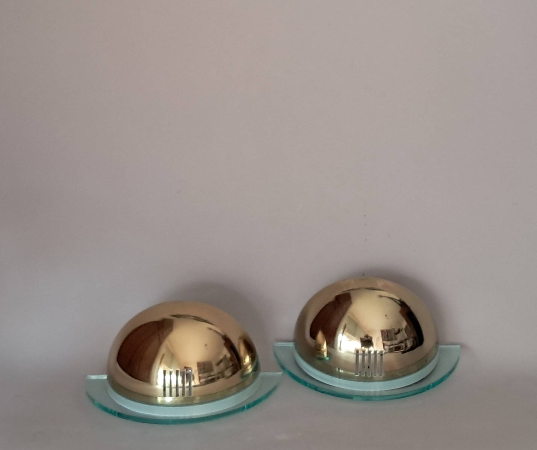 Pair of gold metal and plexiglass wall lights, circa 1980.