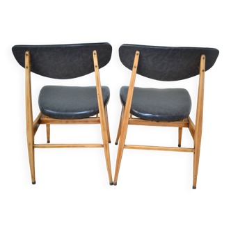 Two chairs from the 1960s – faux leather seats and backs – wooden structure.