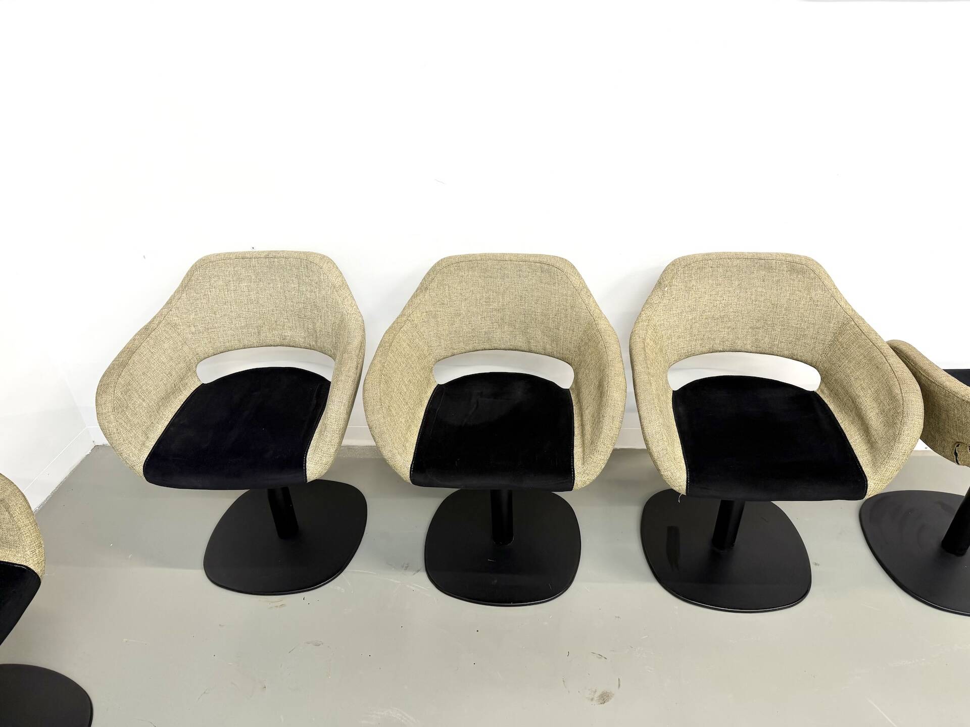 Series of six swivel chairs with an organic shell, patterned fabric and base.