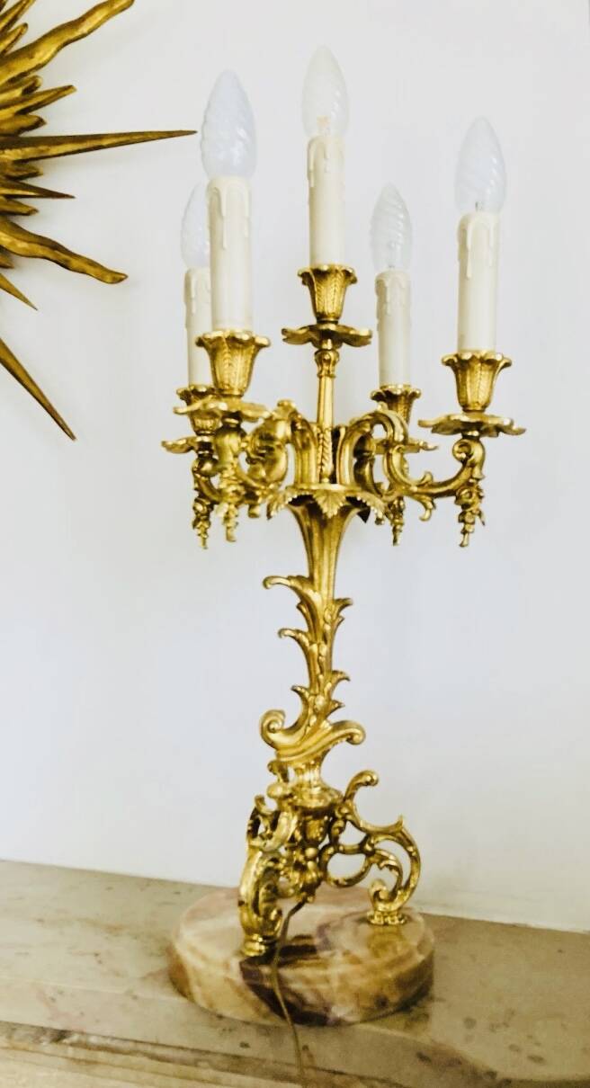 Massive gilded bronze chandeliers from the mid-20th century with marble bases.