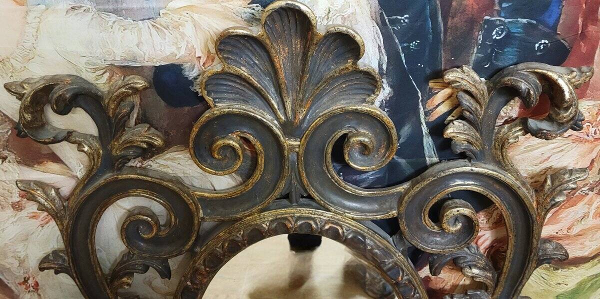 Antique Louis XV style mirror, richly carved with decorations of scrolls, shells, and foliage.