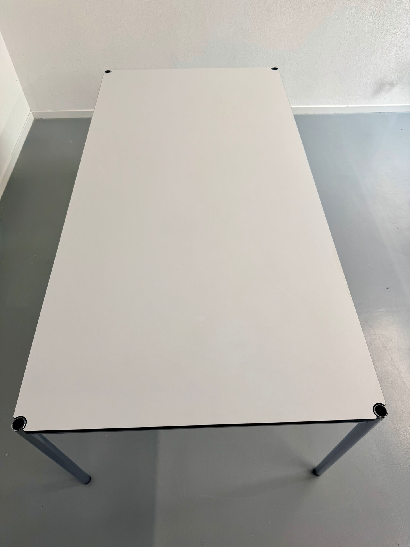 Large table design USM Haller with a white top and chrome structure.